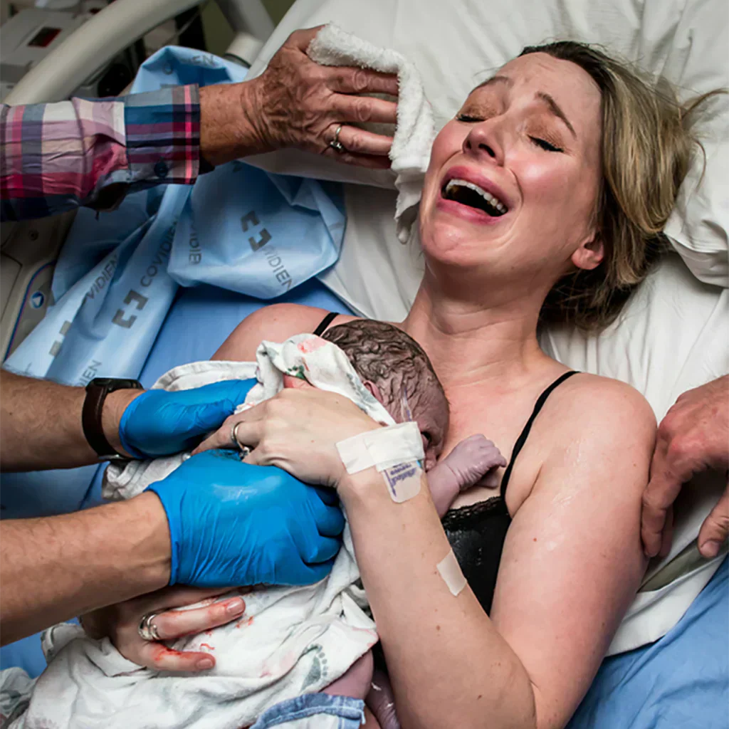 Woman laying in hospital bed aftering giving birth to her baby showing the beauty of childbirth. 